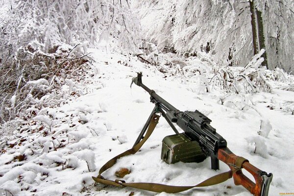 A machine gun on the background of a snow-covered mountain trail