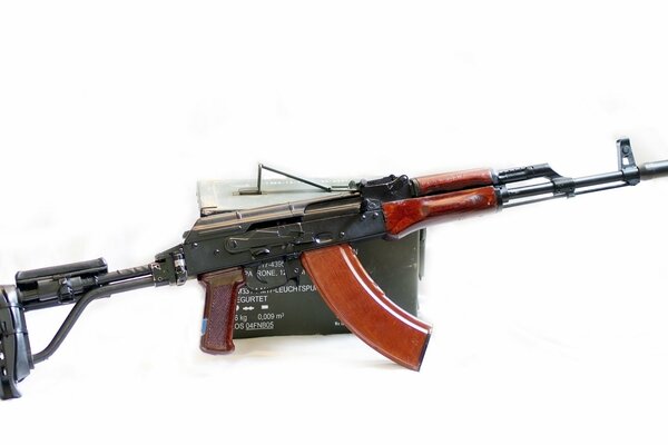 Machine gun with a box of cartridges on a white background