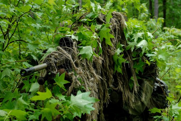 Francotirador enmascarado en los arbustos del bosque