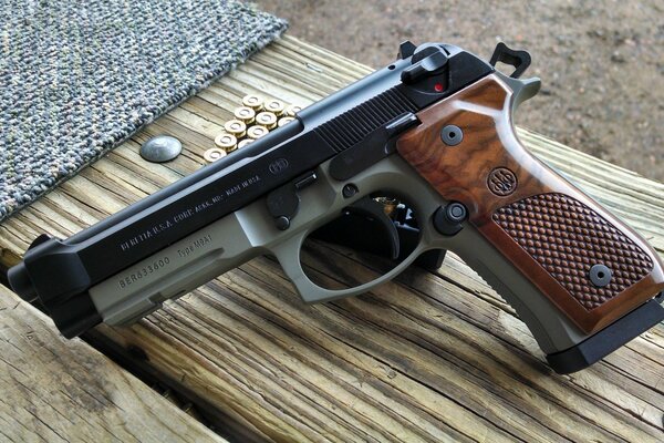 Beretta pistol on the background of a wooden bench