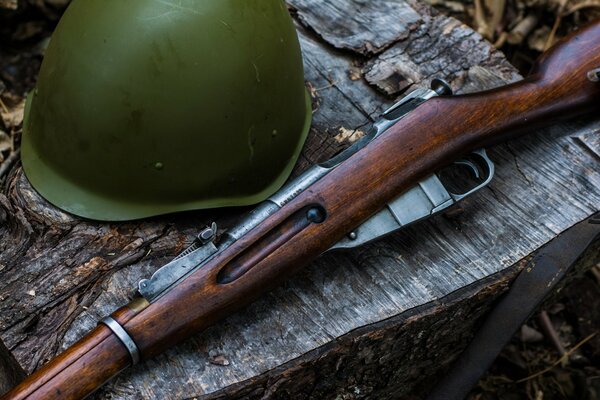 Fusil Mosin et casque couché sur la table