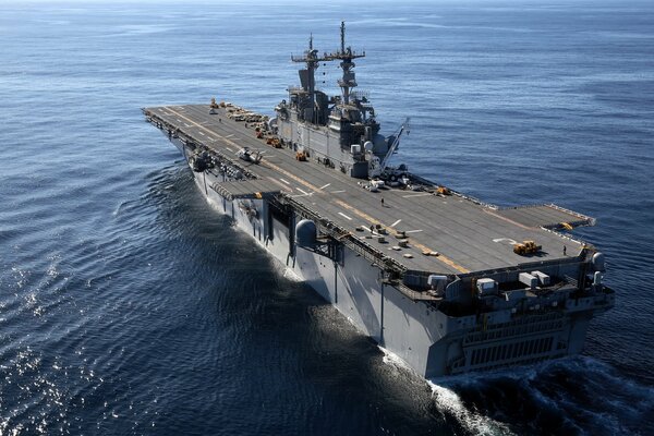 A military aircraft carrier with a landing strip , at sea