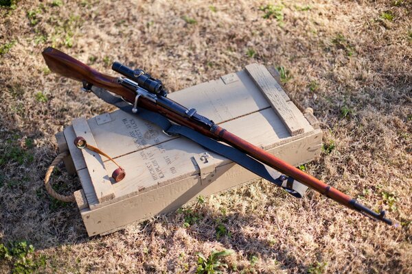 A sniper rifle is lying on a crate