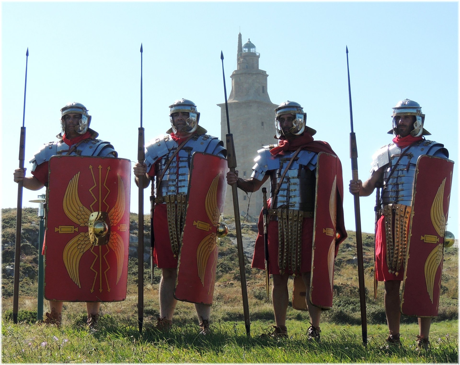 legionarios romanos túnicas armaduras zapatos caliga dardos espadas escudos cascos colina hierba torre reconstrucción histórica militar