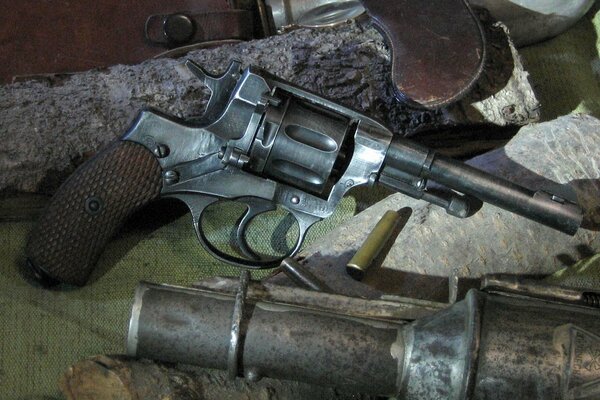 A revolver, a grenade and an empty cartridge case