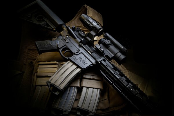 M4 assault rifle with magazines in semi-darkness