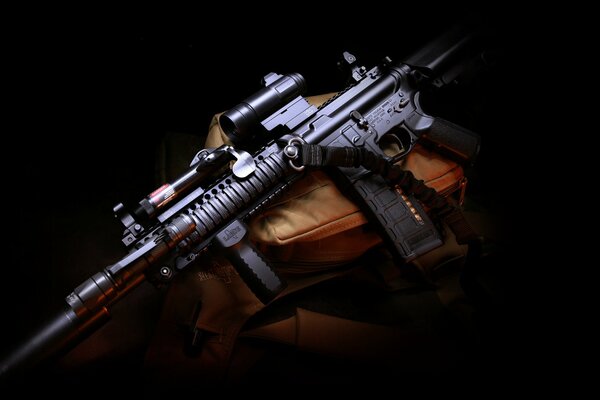 Assault rifle with silencer in semi-darkness