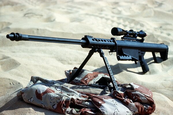 Fusil debout sur le camouflage dans les sables