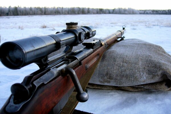 Gewehr auf einem Sack mit dem Zielfernrohr in die Ferne gerichtet