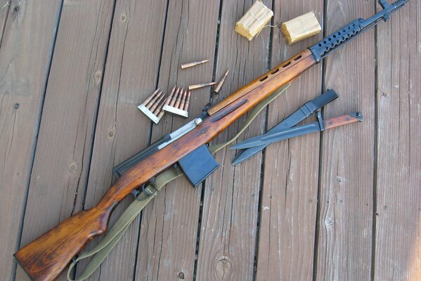 Tokarev s self-loading rifle with cartridges and TNT is on the plank floor