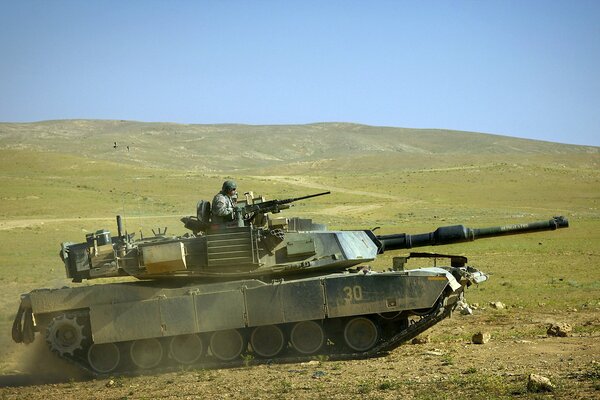Military tank in the field with weapons