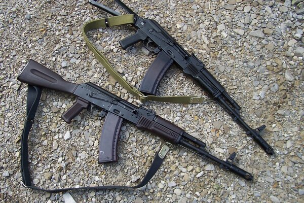 Two Kalashnikov assault rifles on gravel