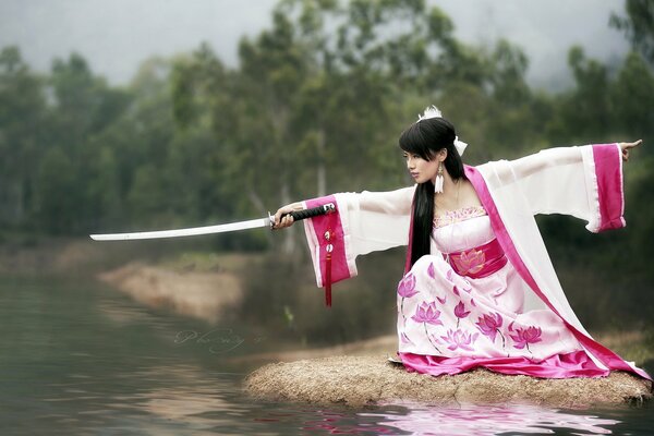 Ragazza con katana sulla riva del fiume