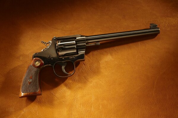 A revolver is lying on a leather background