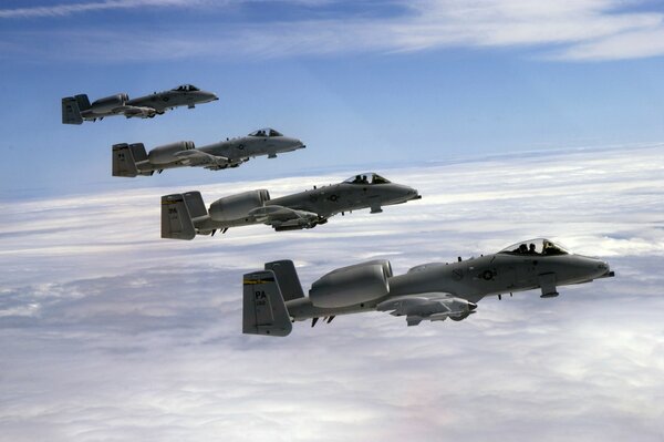 Four thunderbolt fighter jets are flying in the sky