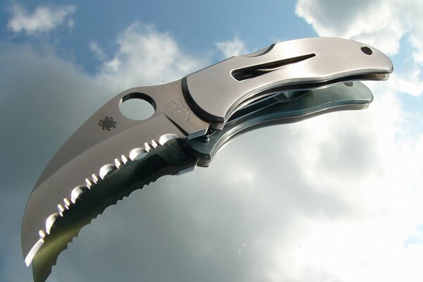 Folding small knife on glass in the clouds