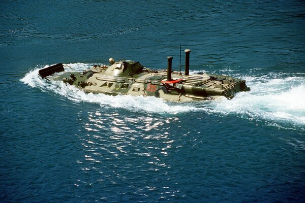 Powerful armored personnel carrier crossing the river