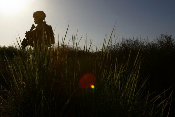 Profil eines bewaffneten Soldaten bei Sonnenuntergang