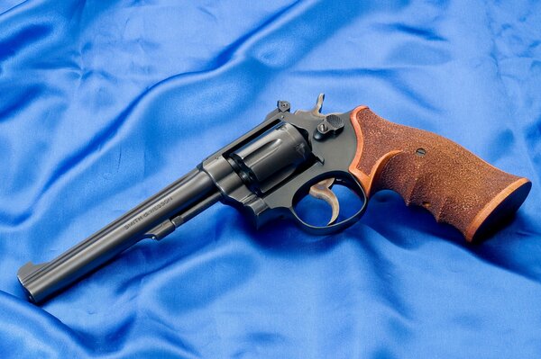 Revolver Smith & Wesson avec manche marron sur soie bleue