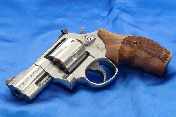 Revolver with wooden design on blue satin