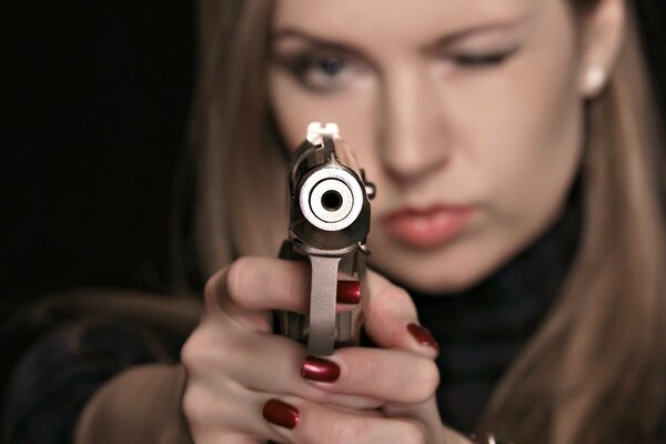 Das Mädchen zielt mit einer Pistole direkt auf dich
