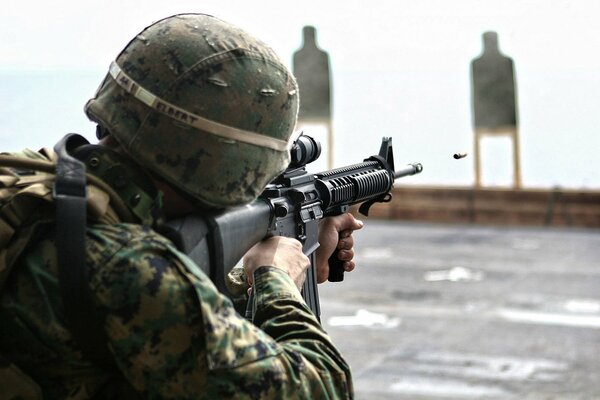 A soldier aims a rifle