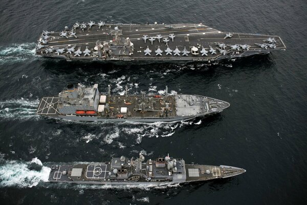 Three aircraft carriers floating on the water