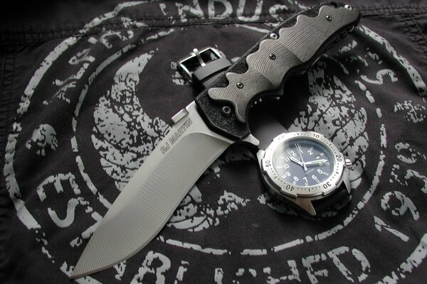 A knife with a wristwatch on a cloth