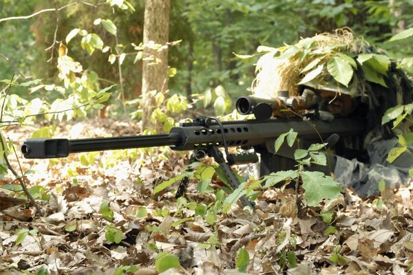 Francotirador en una emboscada forestal con un rifle en la mano