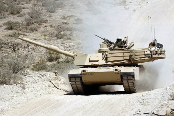 A tank rushing in clouds of smoke and dust