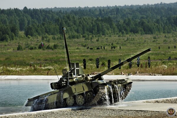 Танк Т-90 выезжает из воды на полигоне