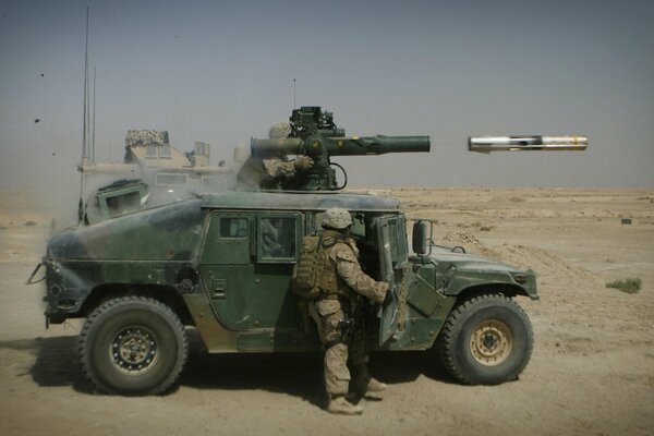 A soldier next to a car firing a rocket