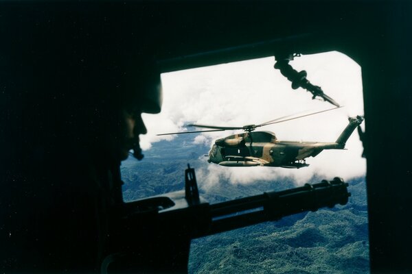 Soldat dans un hélicoptère, en face d un autre avion vole