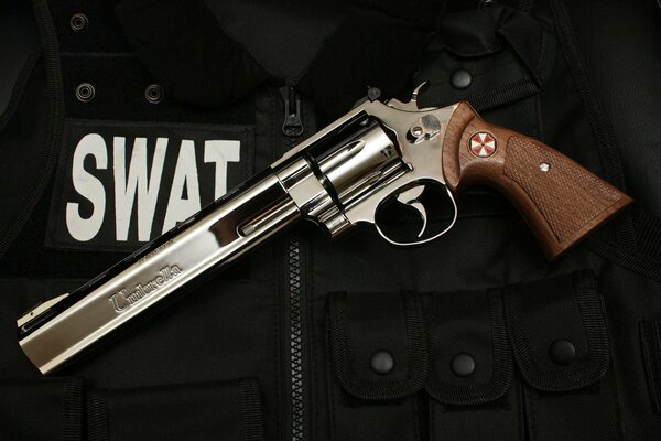 A beautiful revolver with an engraving, on the background of a swat armor