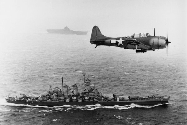 A World War II bomber over an aircraft carrier