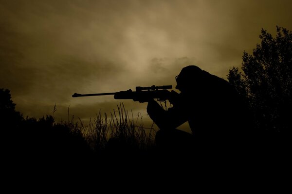 Sniper in a dark field with a gun