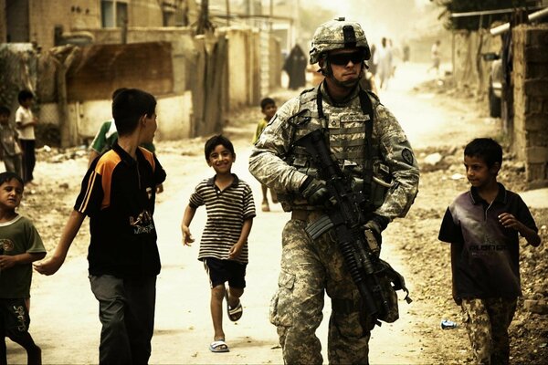 Soldados en la ciudad. Los niños corren detrás de él