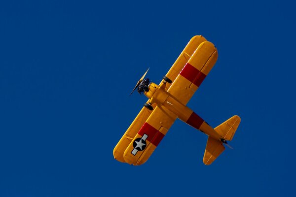 Biplan jaune sur fond de ciel bleu