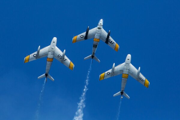 Three planes are flying in the blue sky