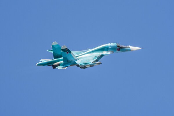 The silvery wings of a fighter jet sparkle in the blue sky