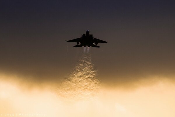 A plane is flying in the beautiful yellow sky