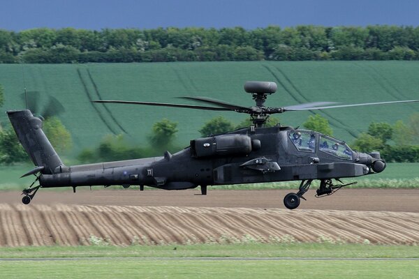 El helicóptero apache ah-64 sobrevuela los campos