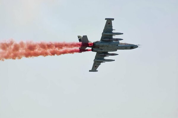 Das Flugzeug am Himmel gibt farbigen Rauch frei. Flugshow