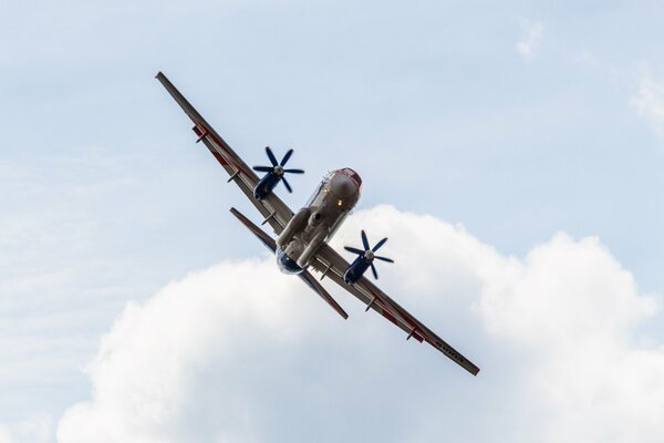 A large plane is flying against the background of clouds