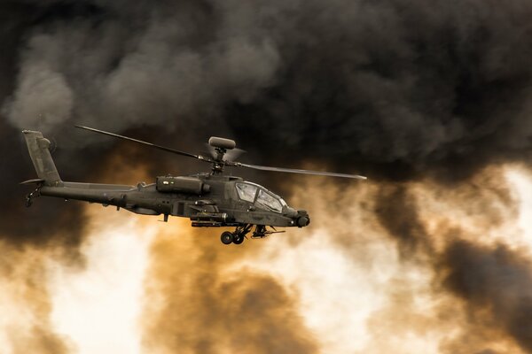Apache-Kampfhubschrauber auf dem Hintergrund von schwarzen Rauchvereinen