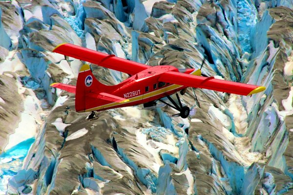 Rotes Flugzeug über schneebedeckten Bergen