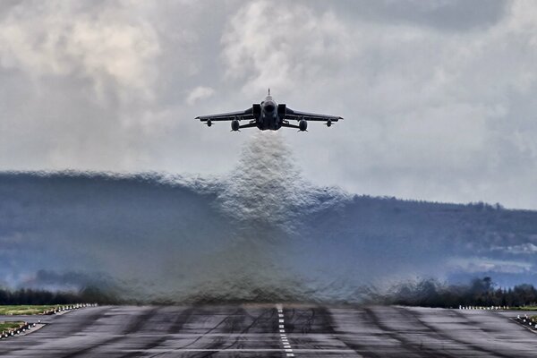 El bombardero de combate despega, el calor difumina el fondo