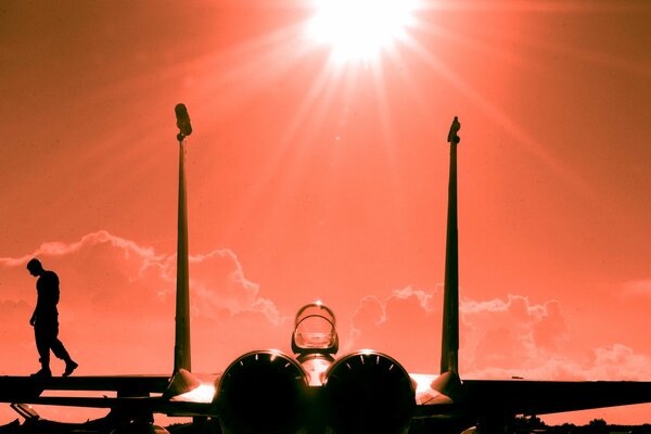 Fighter man on the wing of the sun in the orange filter