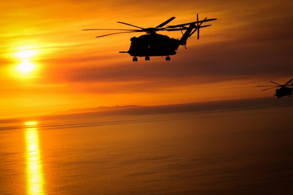 Un gran helicóptero de carga vuela al atardecer