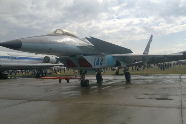 Fighter 1. 44 stands at the airfield among a lot of people